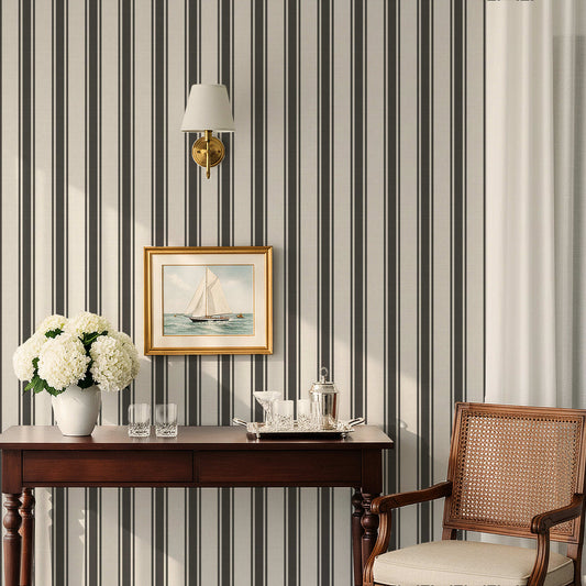 White and black preppy striped wallpaper with linen finish in a classic interior with wood desk and framed sailboat art