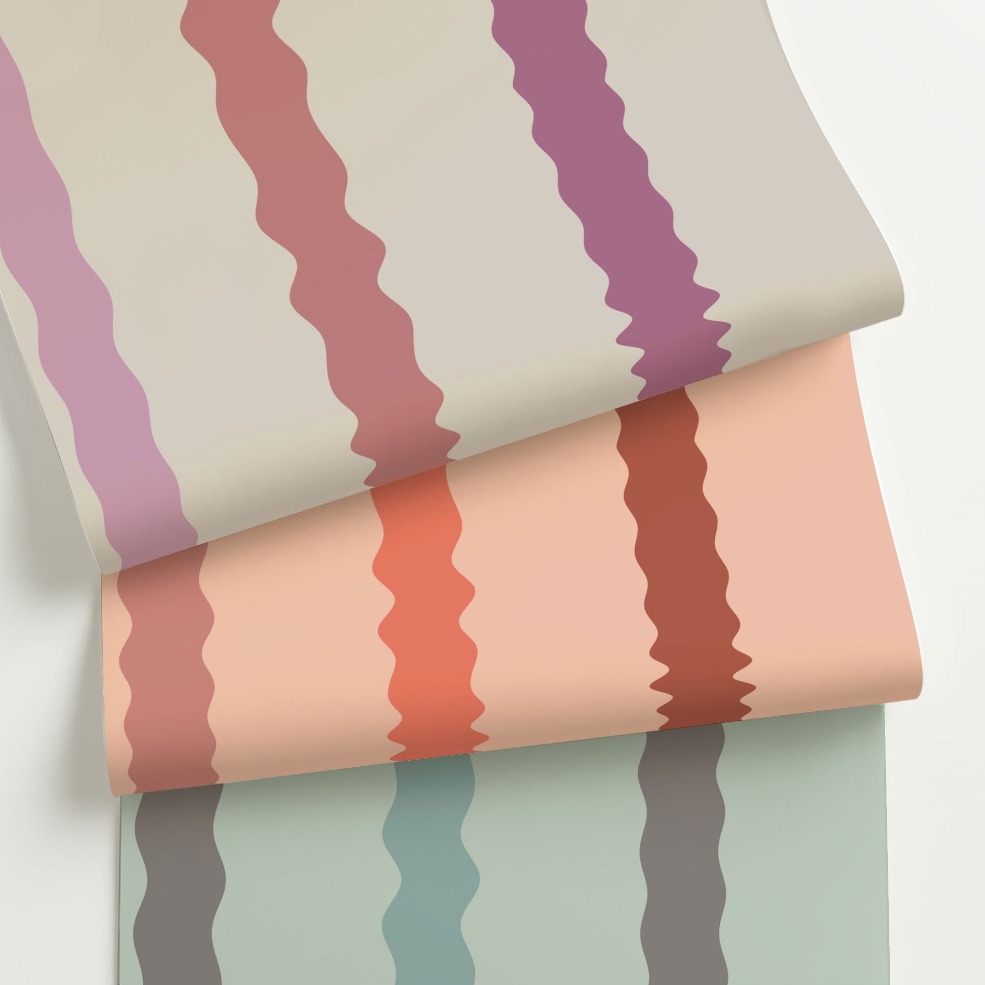 Three colorways of Maiden, a playful wavy stripe wallpaper with hand-drawn curves in warm, modern palettes—rolled to show variety and texture.